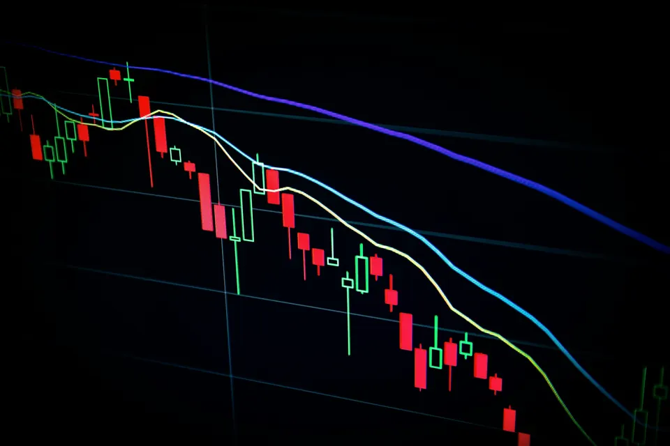 Candlestick price chart falling on a dark screen