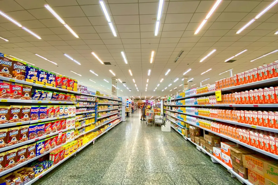 A long supermarket aisle with full shelves