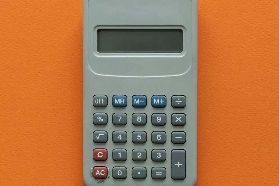 A grey calculator on an orange background